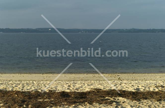 Förde, weißer Strand vor blauem Wasser